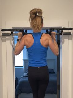 a woman is doing exercises on the pull up bar