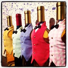 six bottles of wine are lined up in a row with bows on their heads and neck ties