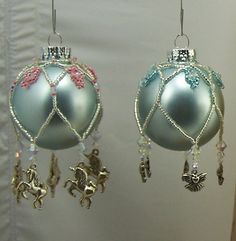 two ornaments hanging from hooks on a wall