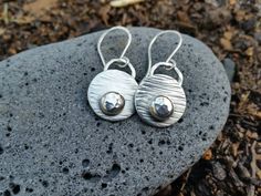 A gorgeous rustic pair of sterling silver earrings. These are those sweet everyday go to earrings. A hint of silver glimmer to add a bit of flair in the hair! The sterling silver discs measure 19mm wide and the total length is over 1 1/4 inches long from the top of the ear wire. I consider these a medium size earring and are light in weight. I textured the disc to mimic tree bark and added drops of recycled silver gently hammered to add a bit of silver shimmer. All silver has been given patina a Silver Hand Forged Earrings For Everyday, Hand Forged Rustic Earrings For Gift, Rustic Hand Forged Earrings For Gift, Rustic Sterling Silver Dangle Earrings, Rustic Sterling Silver Earrings, Rustic Sterling Silver Jewelry In Silver, Rustic Silver Dangle Earrings, Rustic Hand Forged Silver Earrings, Tree Bark