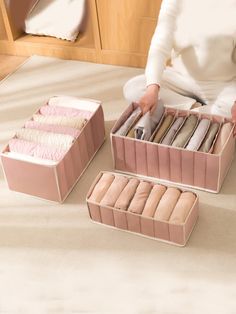 a woman is sitting on the floor with three boxes