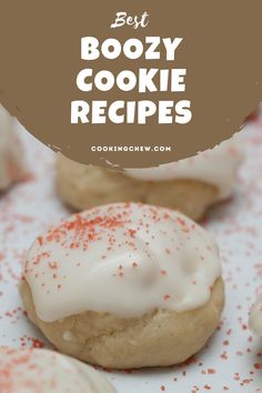 some cookies with white icing and red sprinkles on them are shown