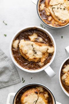 three pots filled with food sitting on top of a white counter next to each other