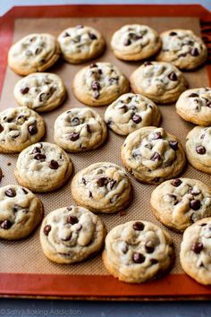 chocolate chip cookies sitting on top of a baking sheet