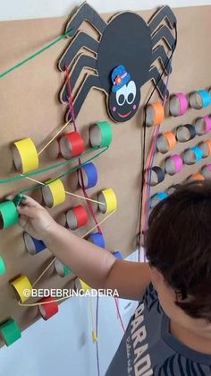 a young boy is playing with an art project