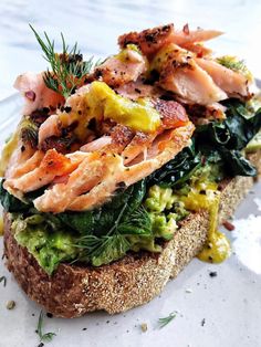 a sandwich with salmon, lettuce and other toppings