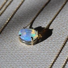 an opal pendant is sitting on the ground