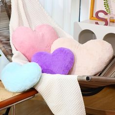 several heart shaped pillows are on a chair