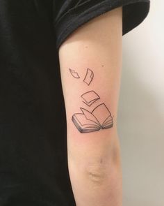 a person with a book tattoo on their arm