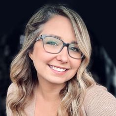 a woman wearing glasses and smiling at the camera