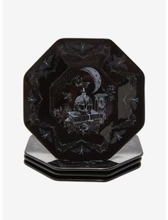 three black plates with designs on them