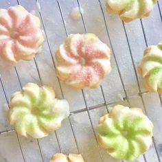 there are many different types of cookies on the cooling rack, including one with green and pink frosting