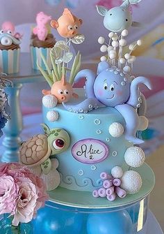 there is a blue cake decorated with animals and sea creatures on the top, along with other decorations