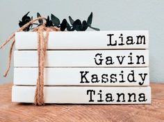 four books tied up with twine and string on top of each other, sitting on a wooden table