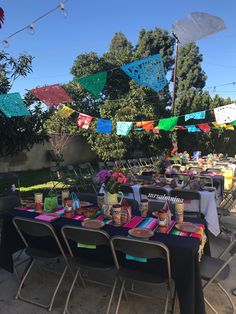 an outdoor party with colorful flags and tables set up for a birthday or baby shower