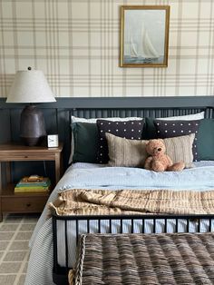 a teddy bear sitting on top of a bed next to a night stand and nightstand