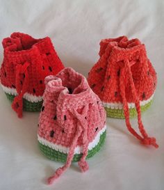 three crocheted watermelon shoes are shown on a white surface