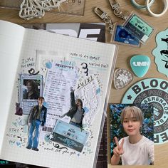 an open book with stickers and key chains on it next to a child's hand