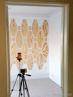 an empty room with a tripod in the foreground and wallpaper behind it