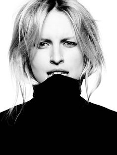 a black and white photo of a woman with blonde hair wearing a turtle neck sweater