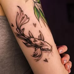 a woman's arm with a bird and leaves tattoo on the left side of her arm