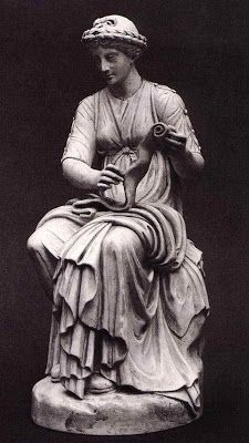 a statue of a woman sitting on top of a stone slab with her hands in her pockets