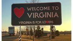 a welcome sign to the city of virginia is posted in front of an interstate highway