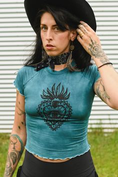 Milagro Sacred Heart Hand Dyed Bamboo Baby Tee Model is wearing a size xs Bohemian Crew Neck Washed Tops, Bohemian Washed Crew Neck Tops, Bohemian Acid Wash Crew Neck Top, Fitted Grunge Blue Top, Fitted Casual T-shirt For Alternative Fashion, Trendy Short Sleeve Tops For Alternative Fashion, Acid Wash Bohemian Short Sleeve Tops, Bohemian Acid Wash Short Sleeve Tops, Y2k Short Sleeve Tops For Alternative Fashion