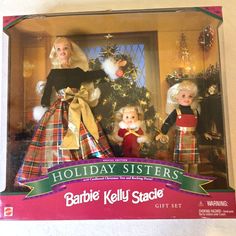 two dolls are posed in front of a christmas tree