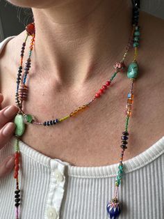 Dive into the world of vibrant gemstones with our Extra Long Boho Color Block Necklace, an exquisite 54-inch masterpiece that pays homage to the rich tapestry of nature's hues. This necklace is not just an accessory; it's a captivating journey through a spectrum of colors, handcrafted by none other than George, a true artisan with a lifelong dedication to the craft. What makes this Turquoise Necklace truly exceptional is its versatility. At 54 inches in length, it can be artfully double-wrapped Artisan Jewelry With Colorful Adjustable Beads, Artisan Adjustable Colorful Beaded Jewelry, One Of A Kind Multicolor Healing Necklaces, Multicolor Czech Glass Necklace One Of A Kind, Adjustable Gemstone Beaded Necklaces With Dangle, Bohemian Rainbow Crystal Necklaces With Faceted Beads, Bohemian Rainbow Crystal Necklace With Faceted Beads, Bohemian Adjustable Jewelry With Faceted Beads, Colorful Beads Adjustable Long Necklace