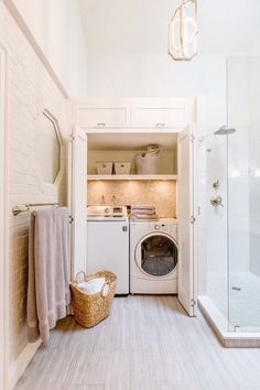 a washer and dryer in a small room next to a walk - in shower