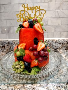 a birthday cake with fruit on the top