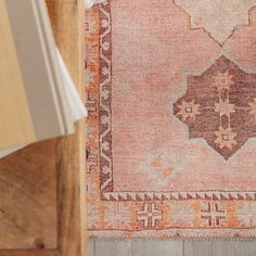 an old rug is laying on the floor next to a wooden box and some books