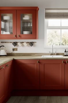 a kitchen with red cabinets and white counter tops