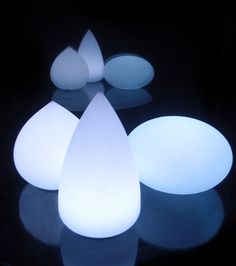 three white lights sitting next to each other on a black surface with reflections in the dark