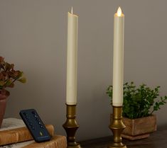 two candles with remote controls sitting on a table