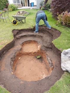 a man digging in the ground with a wheel barrow