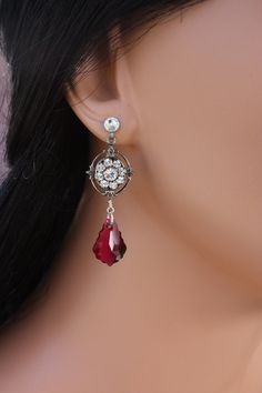 "A great earring for the bridal party or bridesmaids that they can also enjoy wearing after the wedding.  A gorgeous Swarovski crystal dangles from a antiqued silver Swarovski rhinestone filigree flower giving this earring a vintage feel.  They are finished on a post.  It is pictured in clear and ruby but see above for other color choices.  These measure about 1 3/4\" in length." Red Clip-on Jewelry For Wedding, Victorian Clip-on Jewelry For Wedding, Victorian Clip-on Wedding Jewelry, Jeweled Drop Earrings For Wedding, Elegant Jeweled Crystal Earrings For Wedding, Elegant Silver Earrings For Prom, Elegant Silver Jewelry For Prom, Victorian Style Clip-on Earrings For Wedding, Victorian Crystal Jewelry For Wedding