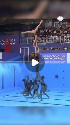 a group of people standing on top of a swimming pool in front of an audience