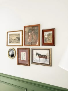 a wall with many framed pictures on it