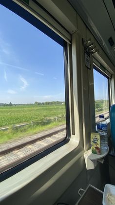 the inside of a train looking out at an open field