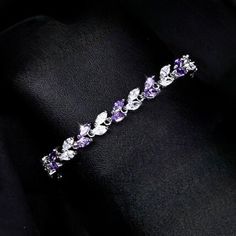 Romantic. Classy. Delicate. Rhodium plated for a flawless finish which perfectly enhances the intricate detailing, this exquisite bracelet will add a touch of sophistication to any wedding gown or formal ensemble. Each link is adorned with flawlessly faceted purple and clear cubic zirconia that capture the light from every angle with a perfectly translucent appeal, sparkling beautifully. Available in two lengths: 6.5" (approx. 16.5cm) and 7.75" (approx. 19.6cm). To make your choice select your p Dainty Cubic Zirconia Formal Bracelets, Dainty Silver Cubic Zirconia Tennis Bracelet, Dainty Sterling Silver Cubic Zirconia Bracelet For Formal Occasions, Elegant Anniversary Charm Bracelet, Elegant Cubic Zirconia Charm Bracelet For Anniversary, Elegant Charm Bracelet For Anniversary, Elegant Cubic Zirconia Crystal Bracelet For Anniversary, Elegant Crystal Bangle With Sparkling Stones, White Gold Cubic Zirconia Bracelet With Elegant Design