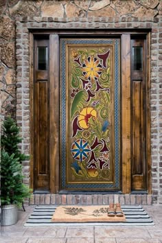 a wooden door with an ornate design on it's side and rug in front