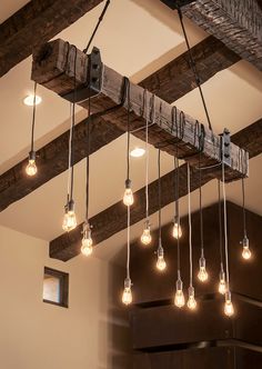 the light bulbs are hanging from the beam in the room, which is decorated with wood beams