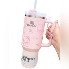 a person holding a pink hello kitty coffee cup