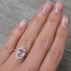 a close up of a person's hand with a diamond ring on their finger