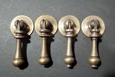 four antique brass door knobs are lined up