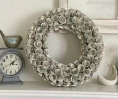 a wreath is sitting on top of a mantle next to a clock and other items