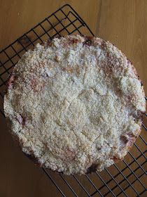 an uncooked pie sitting on top of a wire rack next to a wooden table