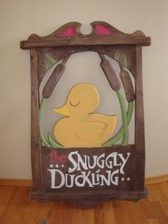 a wooden sign that says the snuggly ducking on it's side